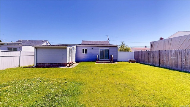 rear view of property featuring a yard