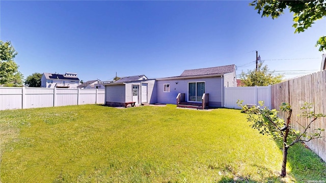 back of house featuring a lawn and an outdoor structure