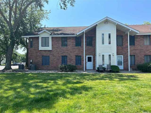 view of front of property with a front yard and central AC