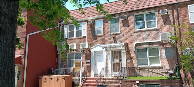 view of front of home with a wall mounted air conditioner