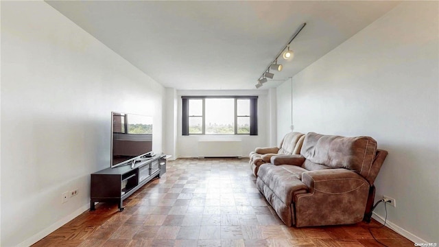 living room featuring rail lighting and radiator