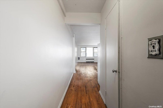 hallway with dark hardwood / wood-style flooring and radiator