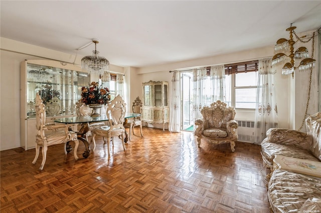 dining area featuring parquet flooring, radiator heating unit, an inviting chandelier, and a wealth of natural light