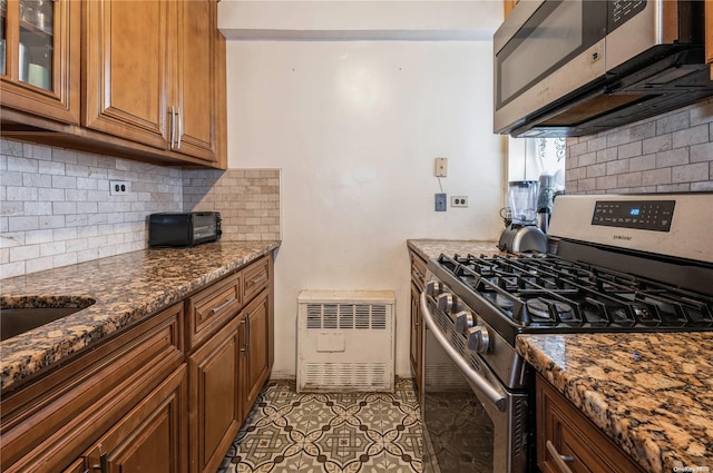 kitchen featuring tasteful backsplash, dark stone countertops, light tile patterned floors, and appliances with stainless steel finishes