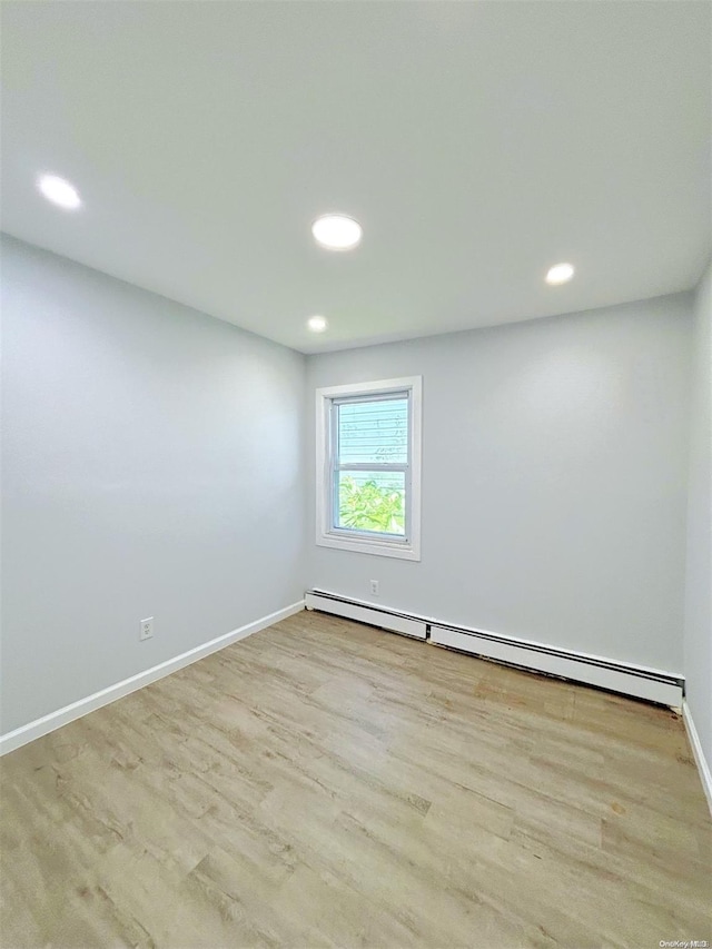 spare room with light hardwood / wood-style flooring and a baseboard heating unit