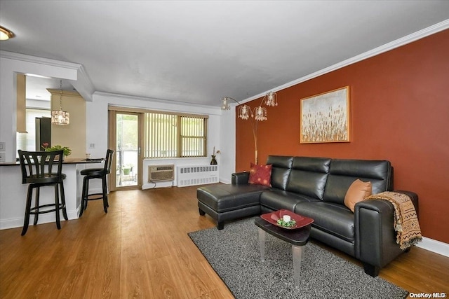 living room featuring hardwood / wood-style floors, radiator heating unit, crown molding, and a wall mounted AC