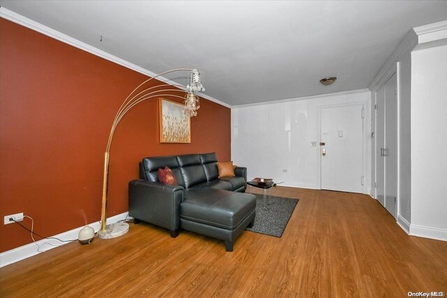 living room with hardwood / wood-style flooring and crown molding