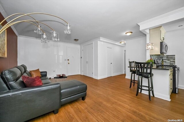 living room with hardwood / wood-style flooring and crown molding