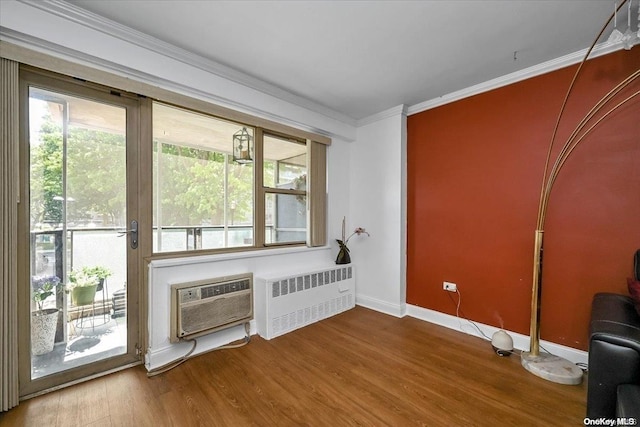 miscellaneous room with hardwood / wood-style flooring, a wall unit AC, radiator, and ornamental molding