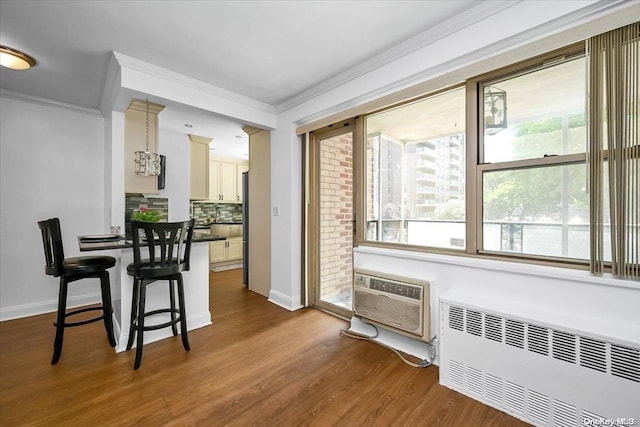 interior space featuring an AC wall unit, radiator heating unit, dark wood-type flooring, and ornamental molding