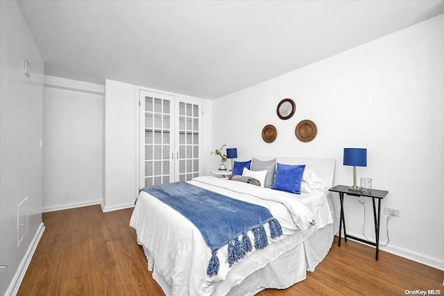 bedroom featuring french doors and hardwood / wood-style flooring