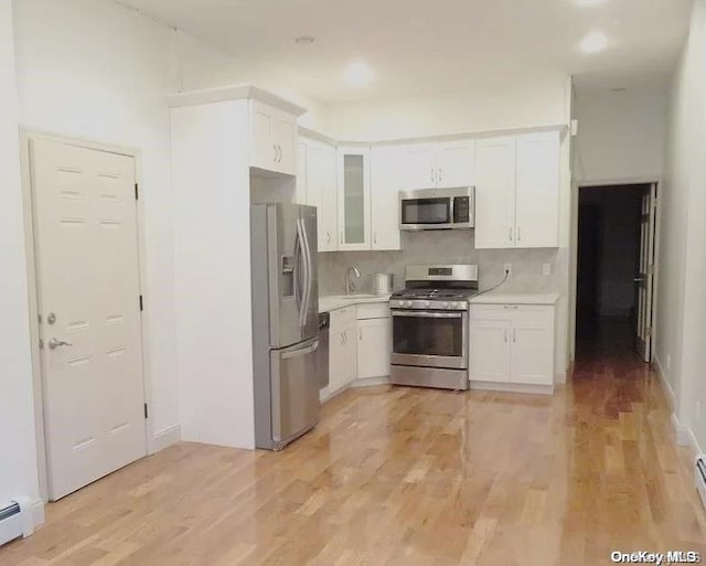 kitchen featuring white cabinets, light hardwood / wood-style floors, and stainless steel appliances