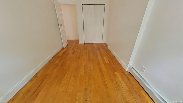 hall with light wood-type flooring and baseboard heating