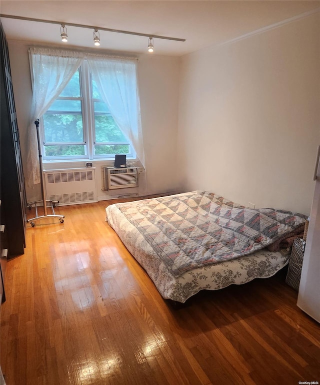 241-20 Northern Blvd Unit 2H, Douglaston, NY 11362 - bedroom with radiator heating unit, light wood-style flooring, track lighting, and a wall unit AC