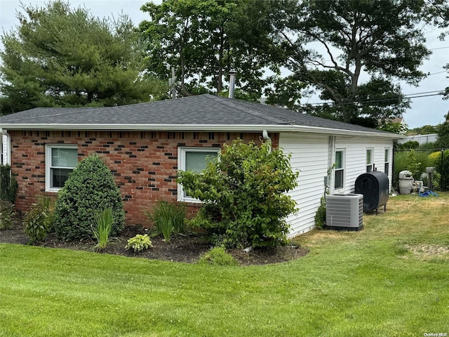 exterior space featuring cooling unit and a yard