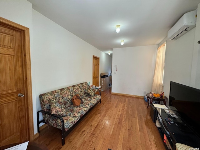 living room featuring light hardwood / wood-style floors and a wall unit AC