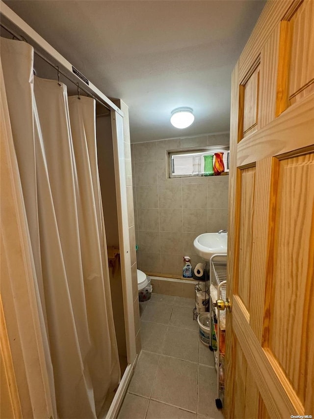 bathroom featuring walk in shower, sink, tile walls, tile patterned flooring, and toilet