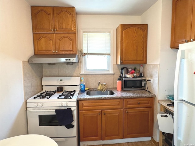 kitchen with sink, extractor fan, white appliances, light hardwood / wood-style floors, and decorative backsplash