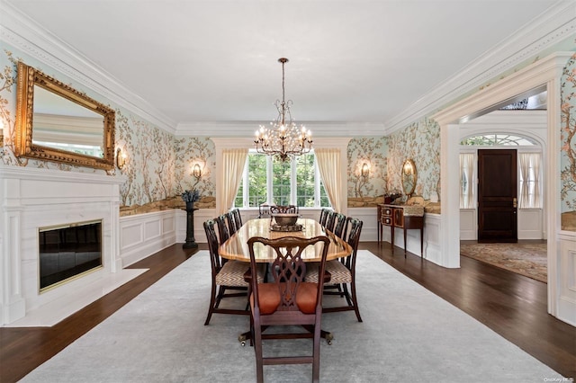 dining space with dark hardwood / wood-style flooring, an inviting chandelier, and ornamental molding