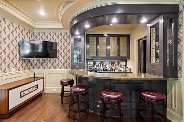 bar featuring dark hardwood / wood-style flooring, white cabinetry, and ornamental molding