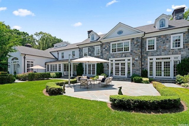 rear view of house with a patio area, an outdoor hangout area, a yard, and french doors