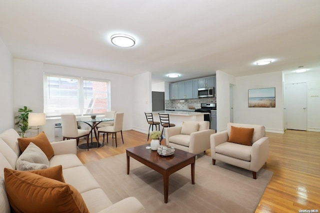 living area featuring light wood-style flooring and baseboards