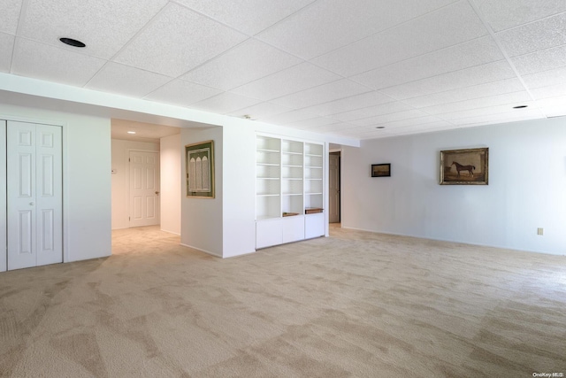 carpeted empty room featuring a paneled ceiling