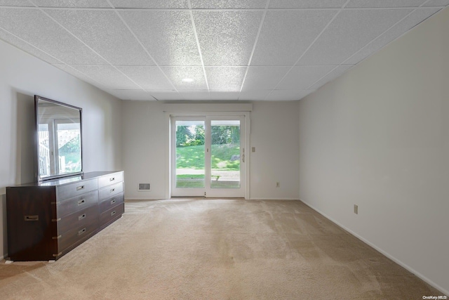 carpeted spare room with a drop ceiling