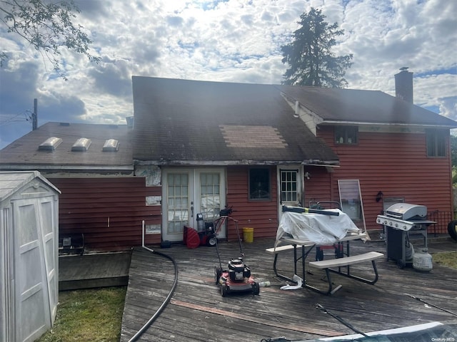 rear view of house featuring a wooden deck, a shed, and a chimney
