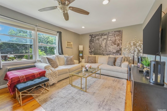 living room with an AC wall unit, ceiling fan, and light wood-type flooring