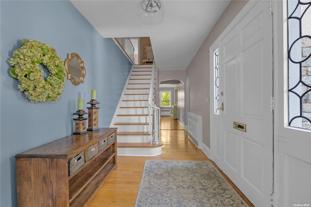 foyer with radiator heating unit and light hardwood / wood-style flooring