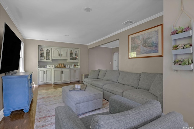 living room featuring light wood-type flooring and ornamental molding