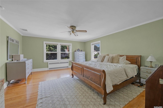 bedroom with radiator, light hardwood / wood-style flooring, ceiling fan, and crown molding