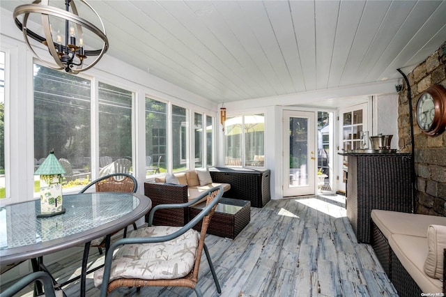 sunroom featuring a chandelier and wood ceiling