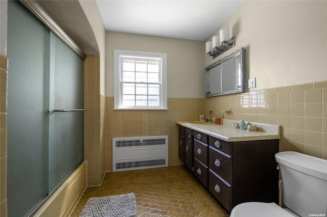 full bathroom with vanity, tile patterned floors, toilet, enclosed tub / shower combo, and tile walls