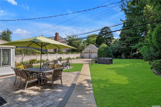 view of patio / terrace featuring an outbuilding, a hot tub, and a garage