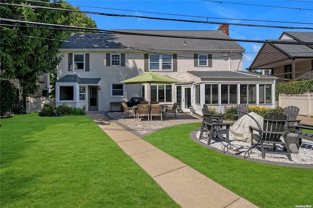 rear view of house featuring a sunroom, a yard, and a patio