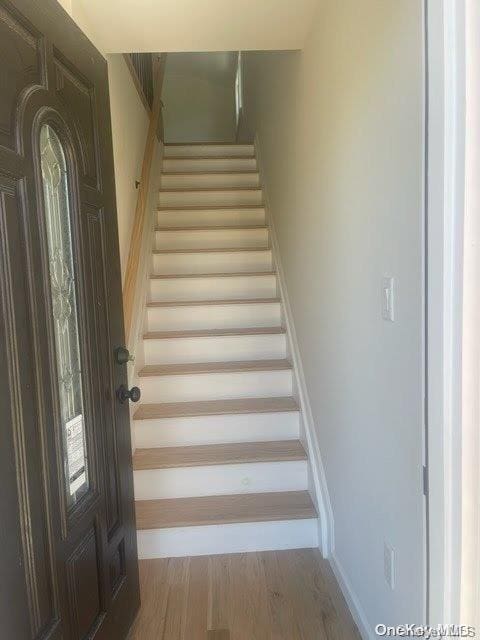 stairs featuring hardwood / wood-style floors