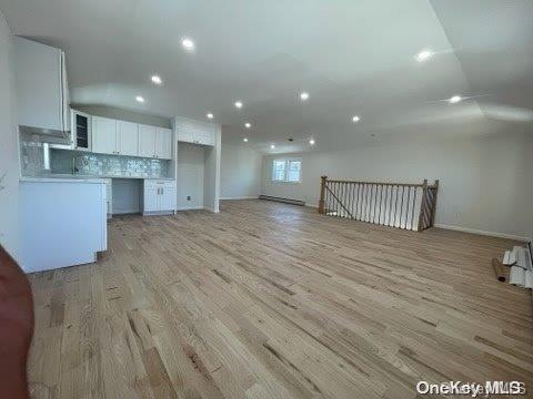 kitchen featuring backsplash, white cabinetry, and light hardwood / wood-style floors