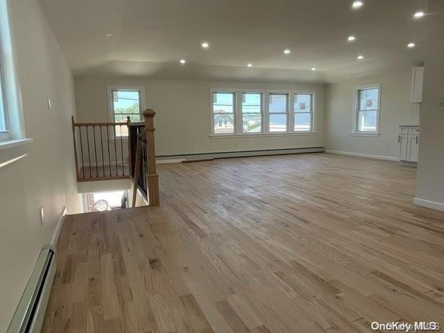 unfurnished living room with a baseboard radiator and light hardwood / wood-style floors