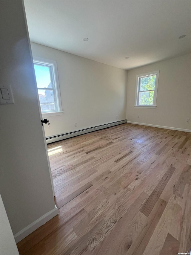 spare room featuring light hardwood / wood-style floors and a baseboard radiator