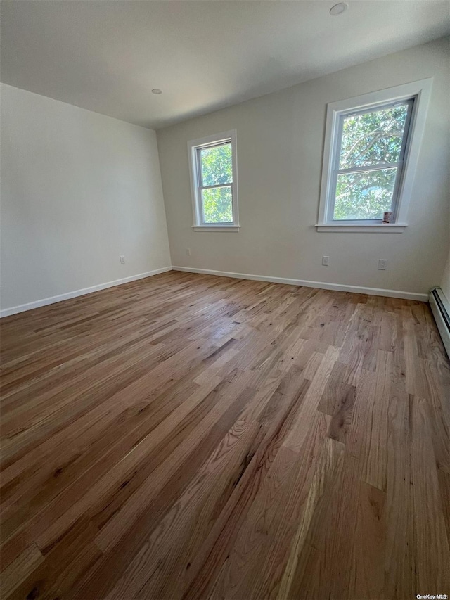 spare room with light hardwood / wood-style floors and a healthy amount of sunlight