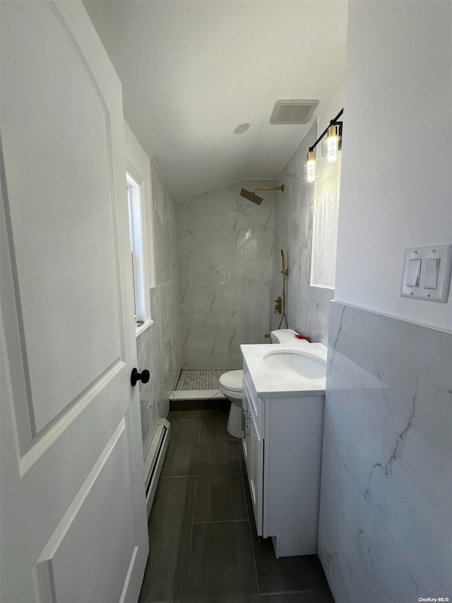 bathroom with baseboard heating, tile walls, and tiled shower