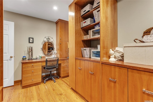 office featuring built in desk and light wood-type flooring