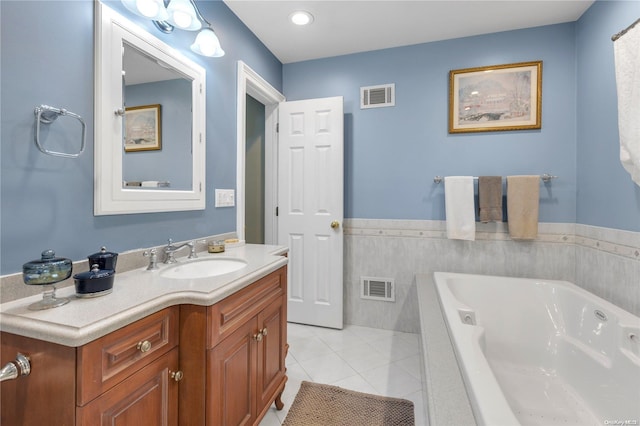 bathroom featuring tile patterned floors, vanity, and tiled tub