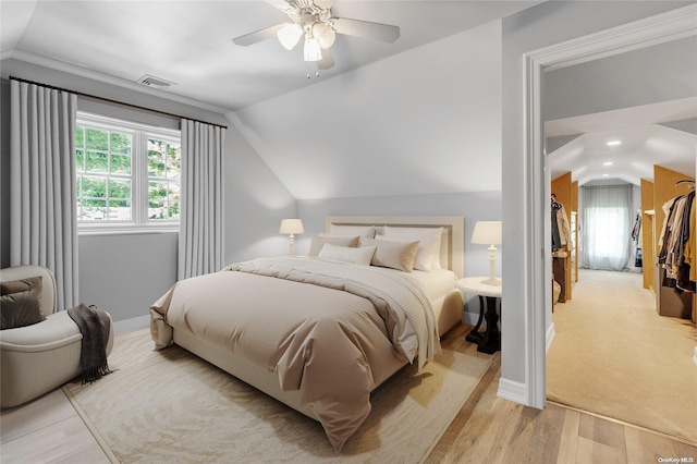 bedroom featuring light wood-type flooring, vaulted ceiling, and ceiling fan