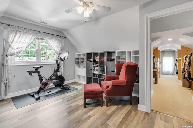 workout area with light hardwood / wood-style floors, vaulted ceiling, and ceiling fan