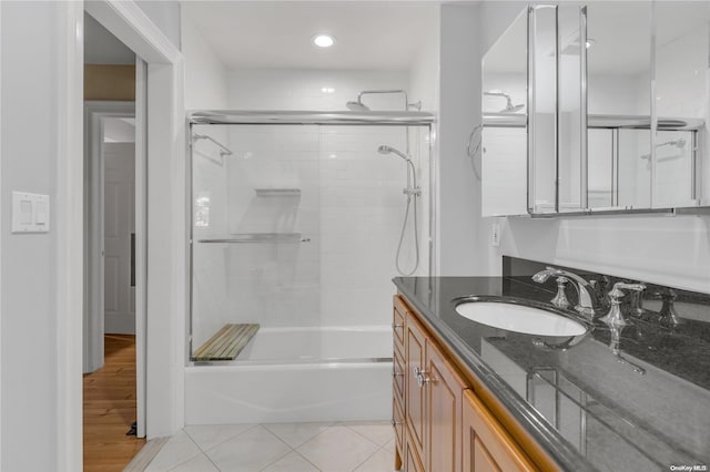 bathroom with tile patterned flooring, vanity, and enclosed tub / shower combo