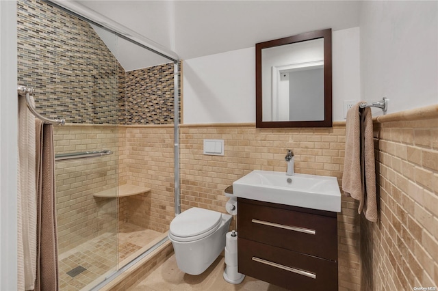 bathroom with a shower with door, vanity, tile walls, and toilet