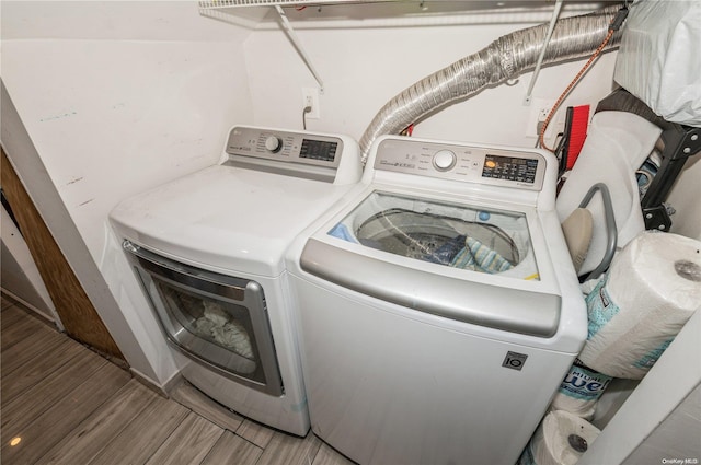 laundry room with washer and clothes dryer and wood-type flooring